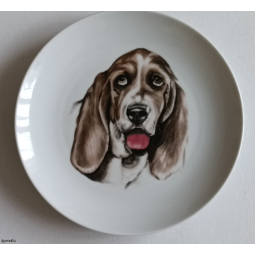 Decorative wall plate featuring a picturesque portrait of a Basset Hound. Diameter: 20 cm.